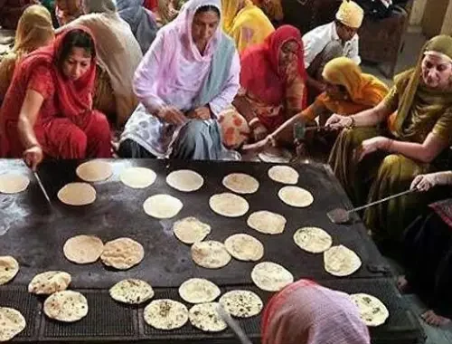 Volunteers preparing or serving langar as seva
